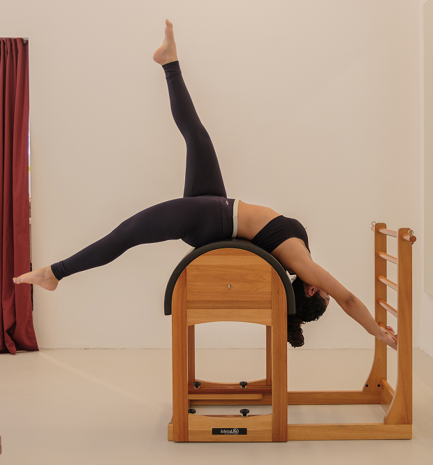 Aluna realizando uma extensão sobre o aparelho Ladder Barrel